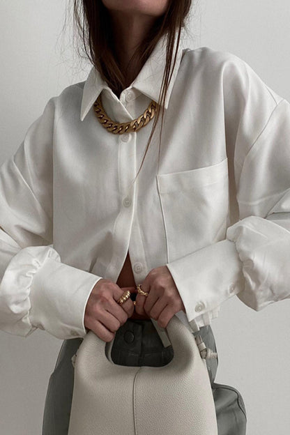 Elegante blusa lisa con cuello vuelto y bolsillos plegables
