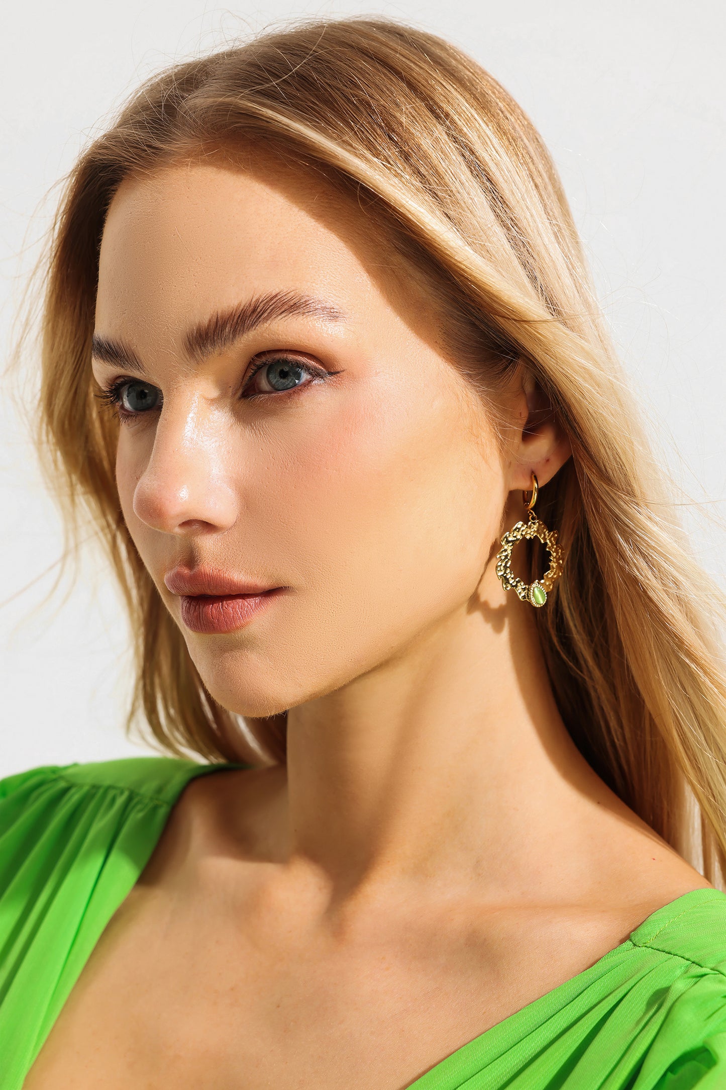 Pendientes de metal con gemas verdes falsas de forma irregular 